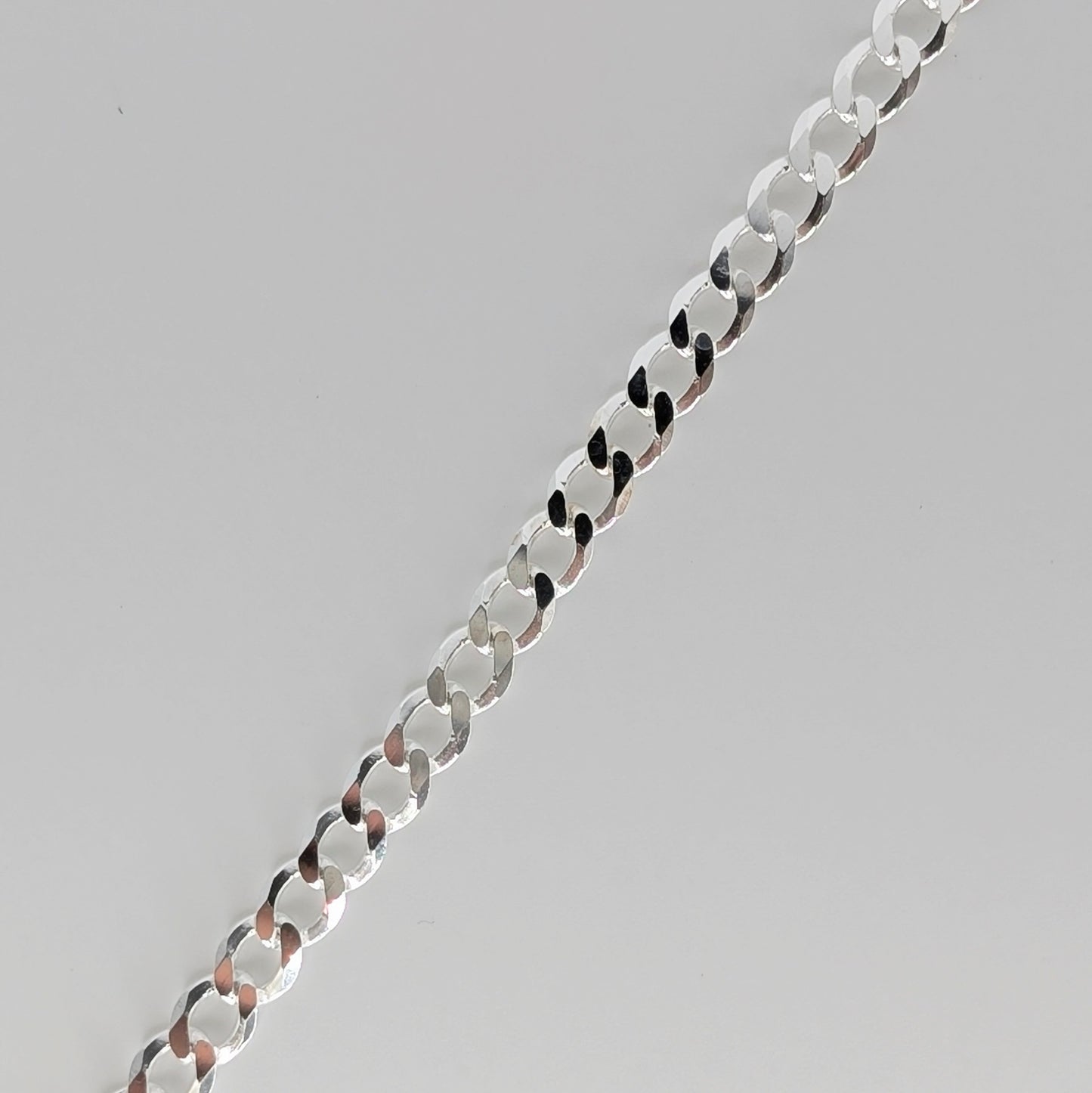 Polished sterling silver chain necklace with flat, circular links.