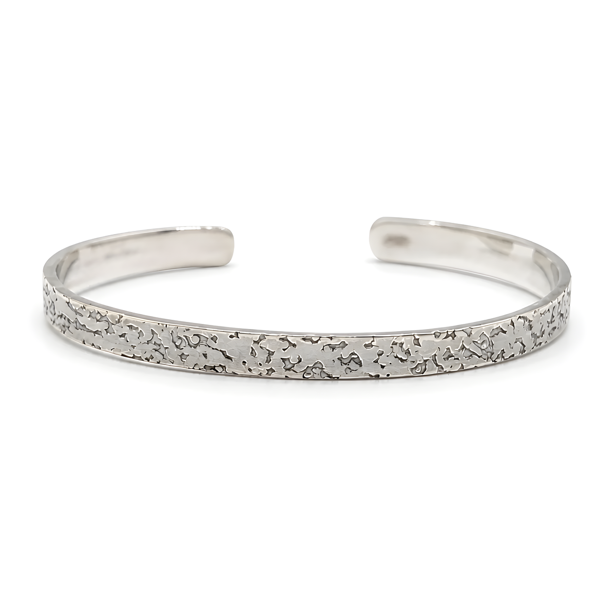 A polished silver cuff bracelet with a textured, hammered pattern along the front band.