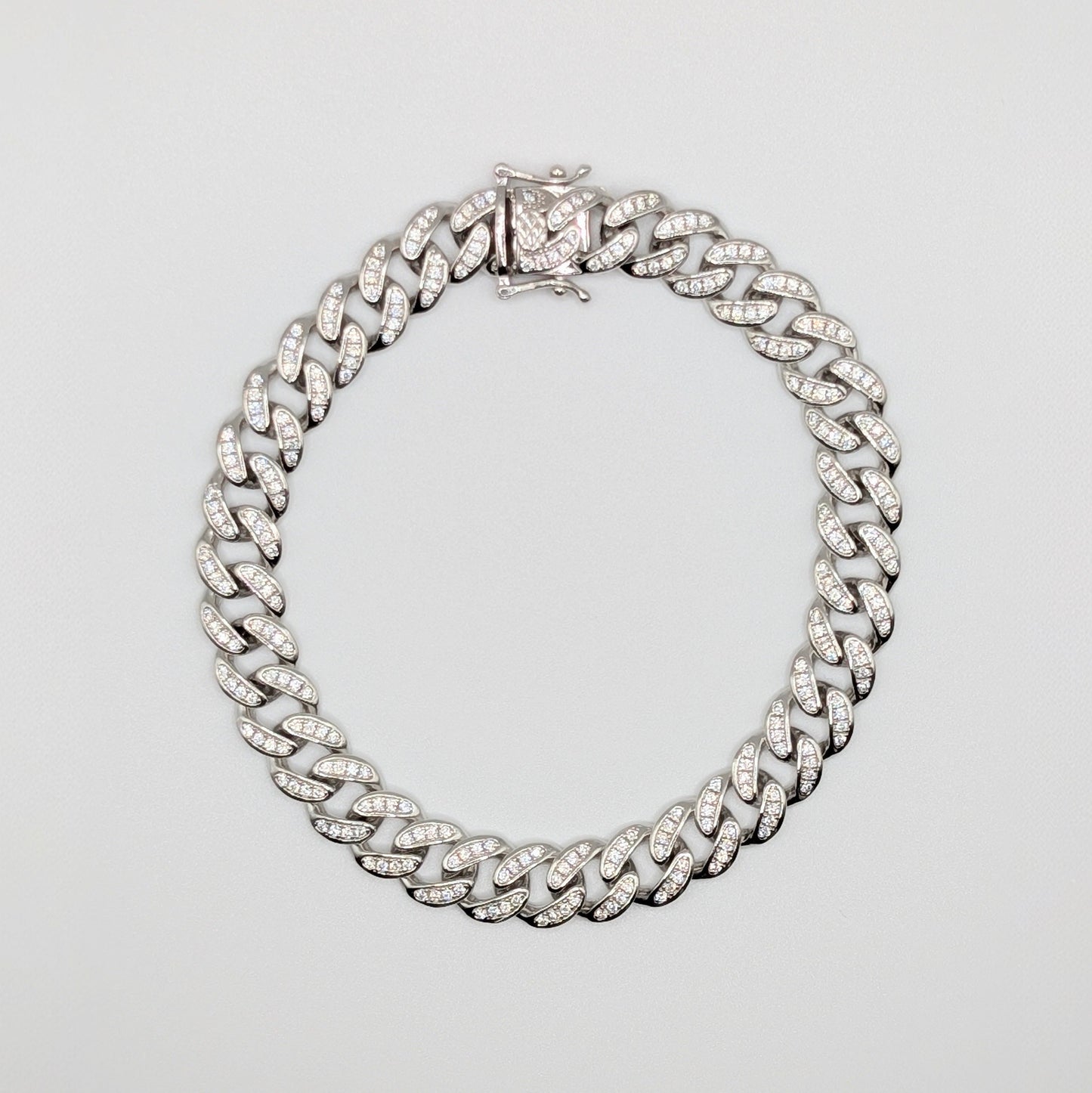 Sterling Silver Iced Curb Cuban Chain Bracelet with brilliant mini Zircon Stones embedded on it.