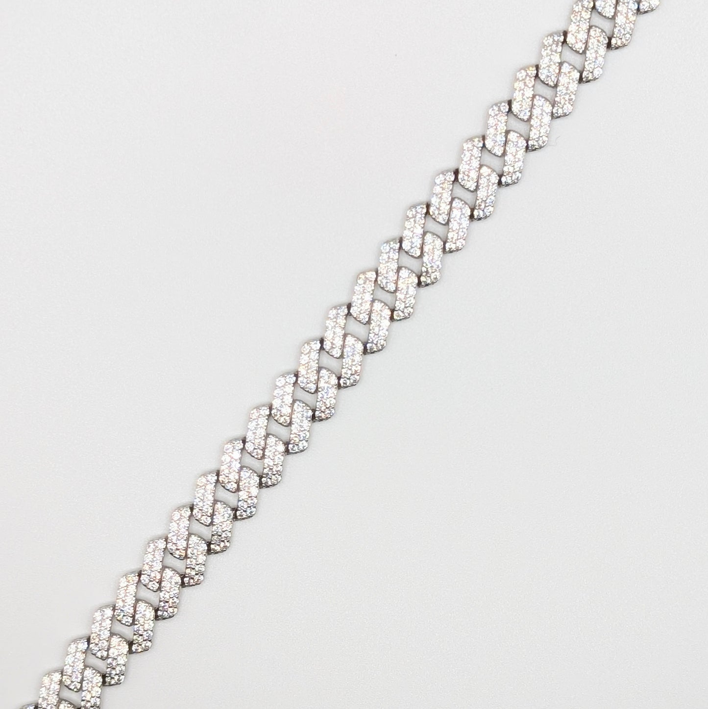 Sterling Silver Iced Curb Cuban Chain Bracelet with brilliant mini Zircon Stones embedded on it.