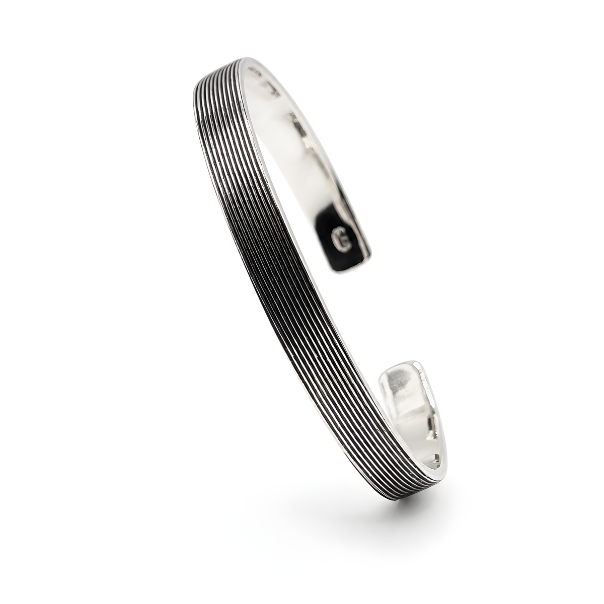 A sterling silver open cuff bracelet featuring a textured, ribbed pattern on the outer surface and a polished, reflective interior.