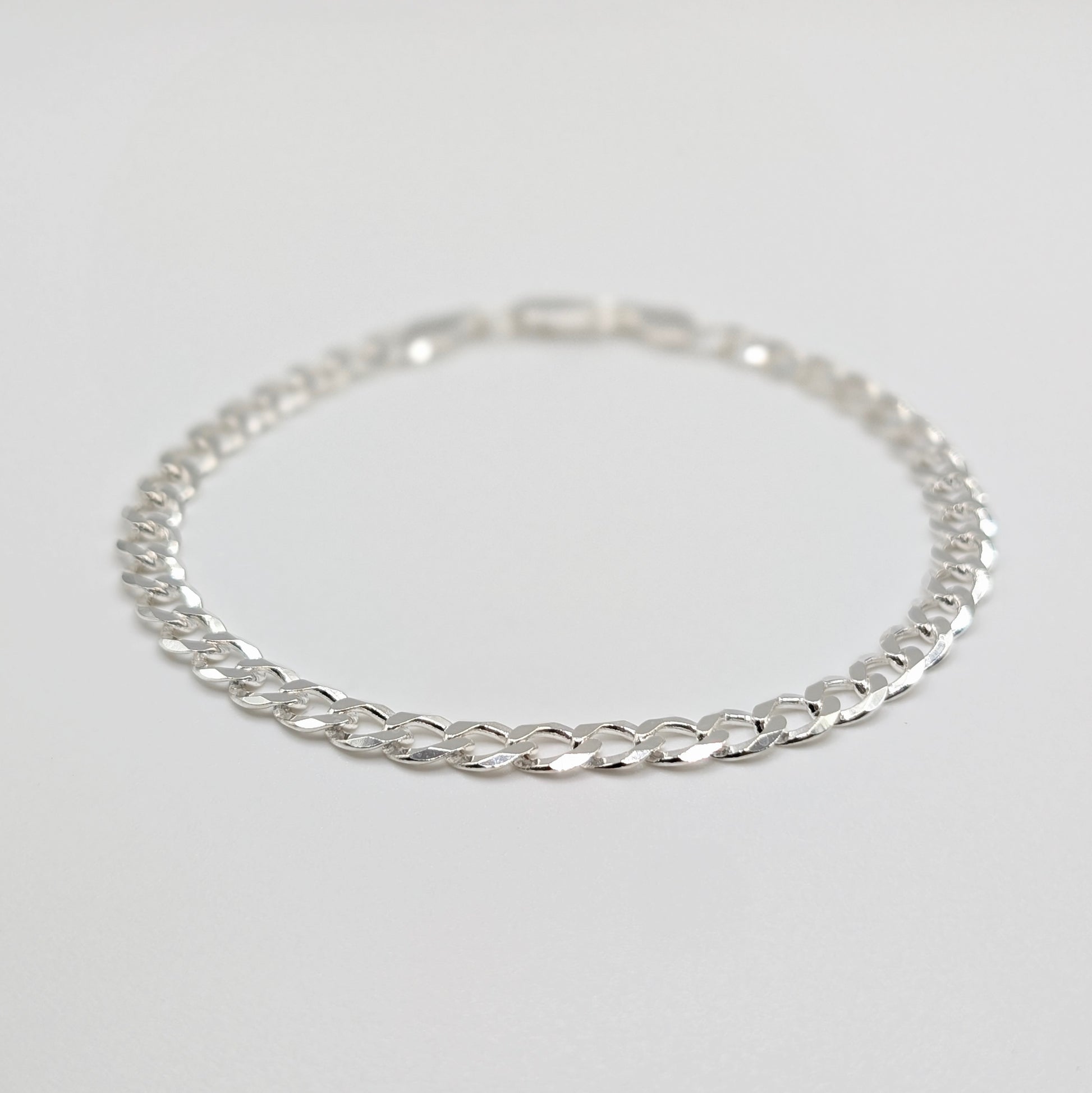 A sterling silver chain bracelet with a curb link design.