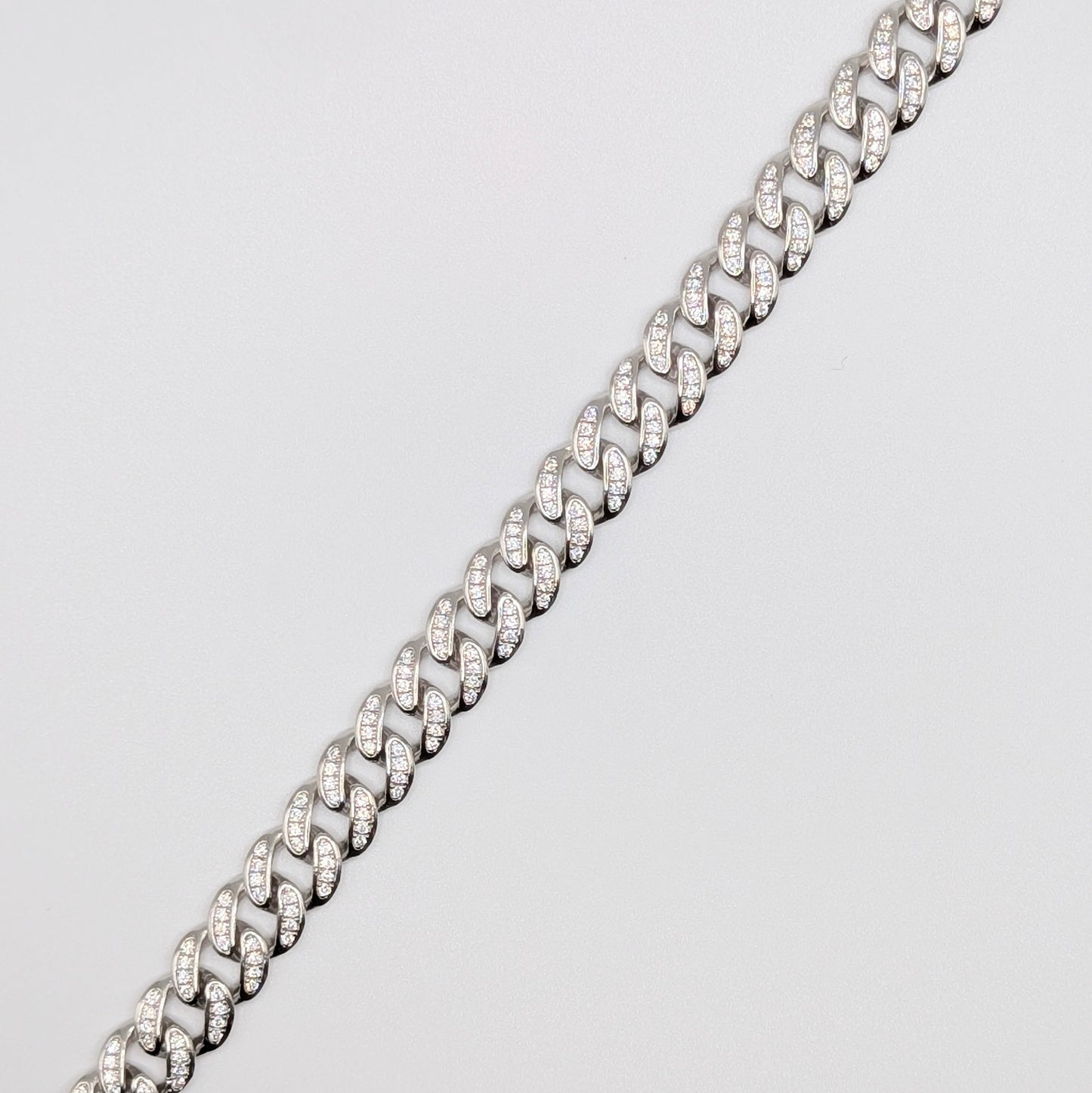Sterling Silver Iced Curb Cuban Chain Bracelet with brilliant mini Zircon Stones embedded on it.