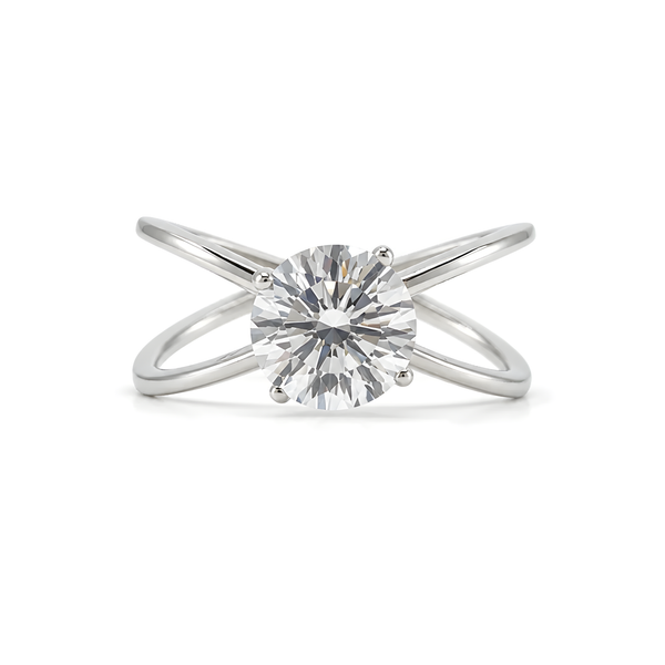 A silver ring with a round-cut clear cubic zirconia in a prong setting, featuring two intersecting curved bands.