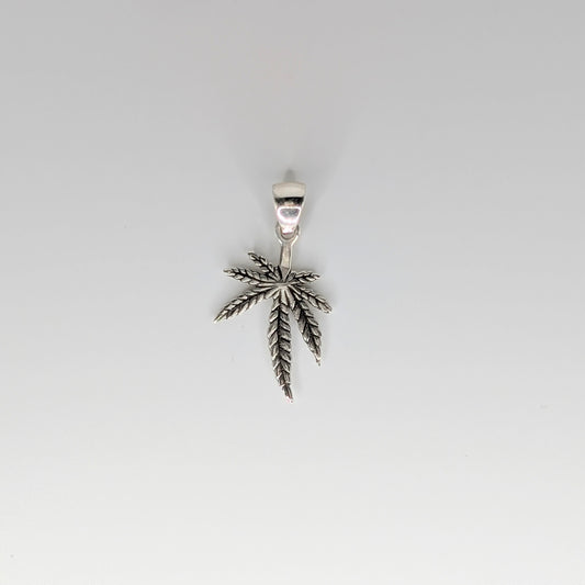 A silver pendant shaped like a cannabis leaf, suspended against a plain light gray background.
