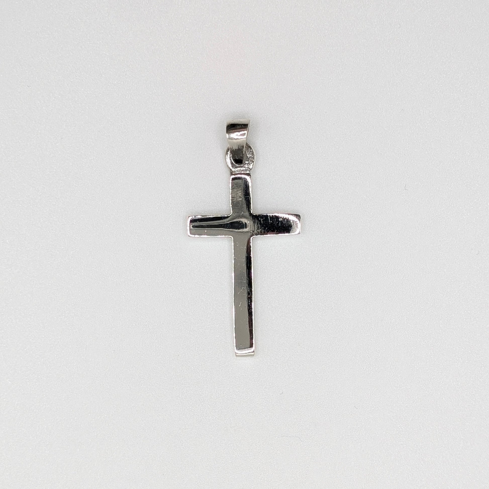 A polished silver cross pendant with a flat, textured surface and a top bail.