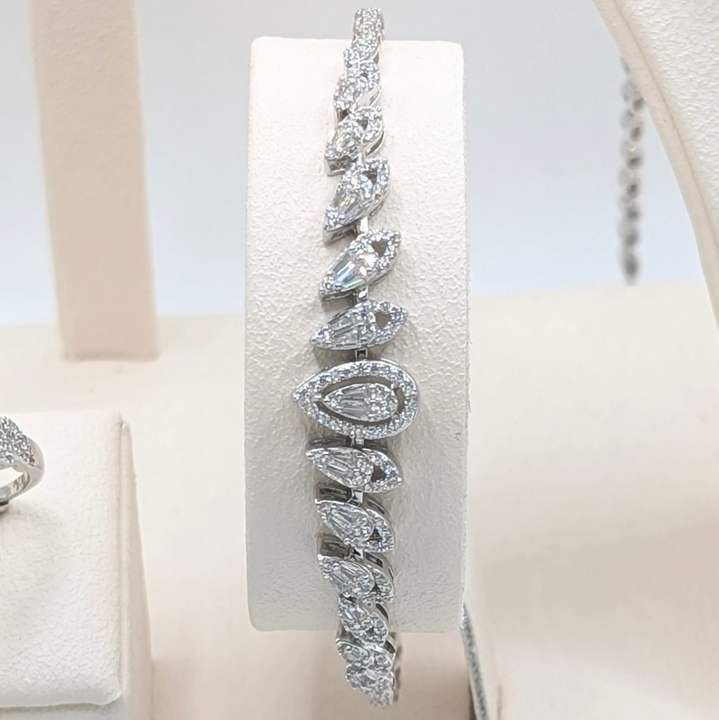 A silver-toned tennis bracelet with a series of teardrop-shaped clear gemstones.