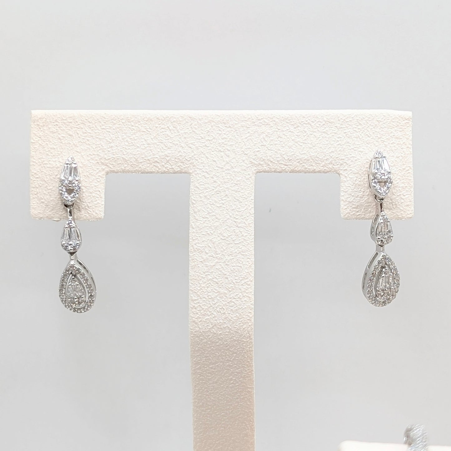 A pair of silver-tone drop earrings with clear teardrop-shaped gemstones.