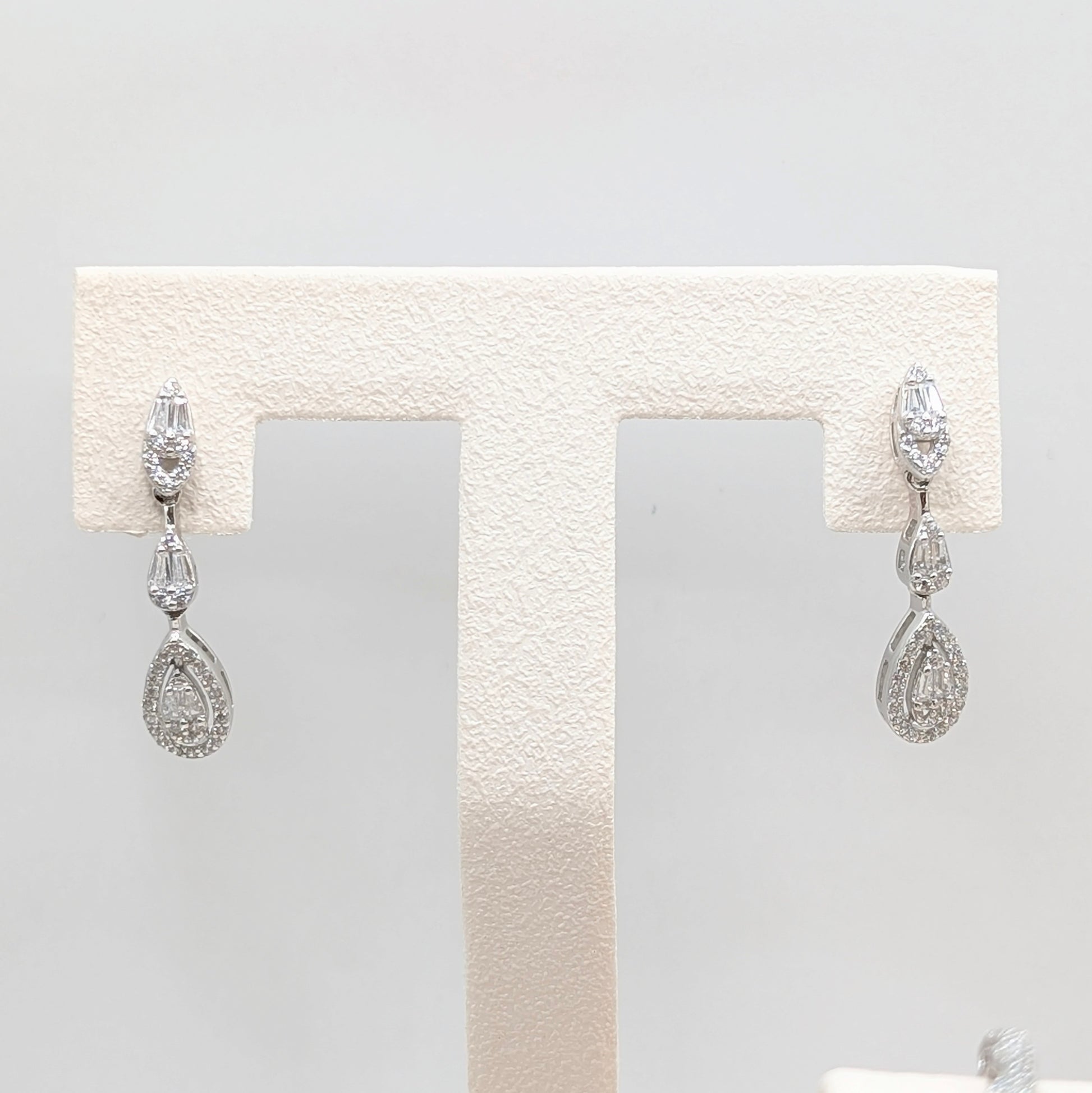 A pair of silver-tone drop earrings with clear teardrop-shaped gemstones.