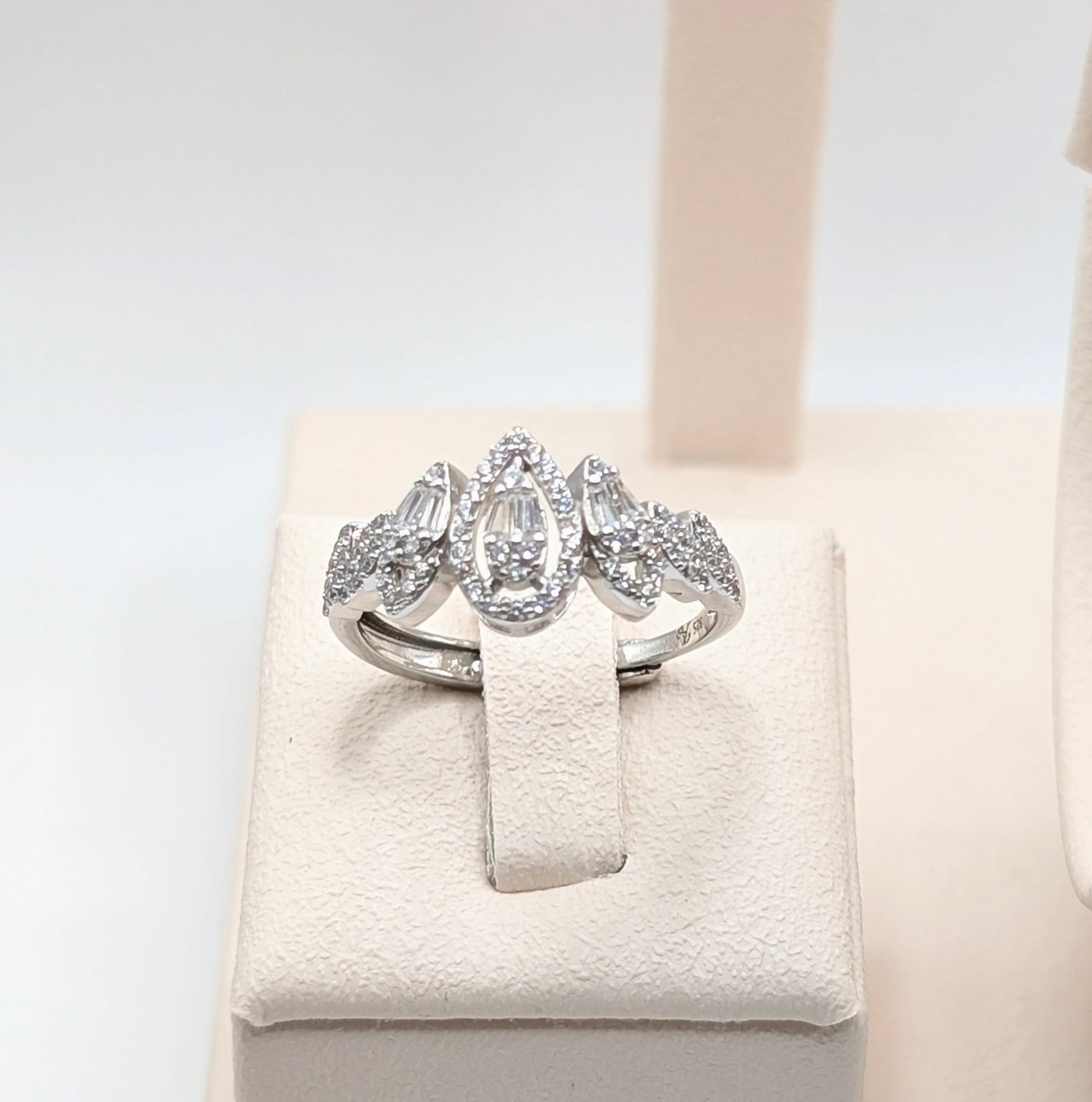 A silver-tone ring with a marquise-cut center stone and smaller round stones.