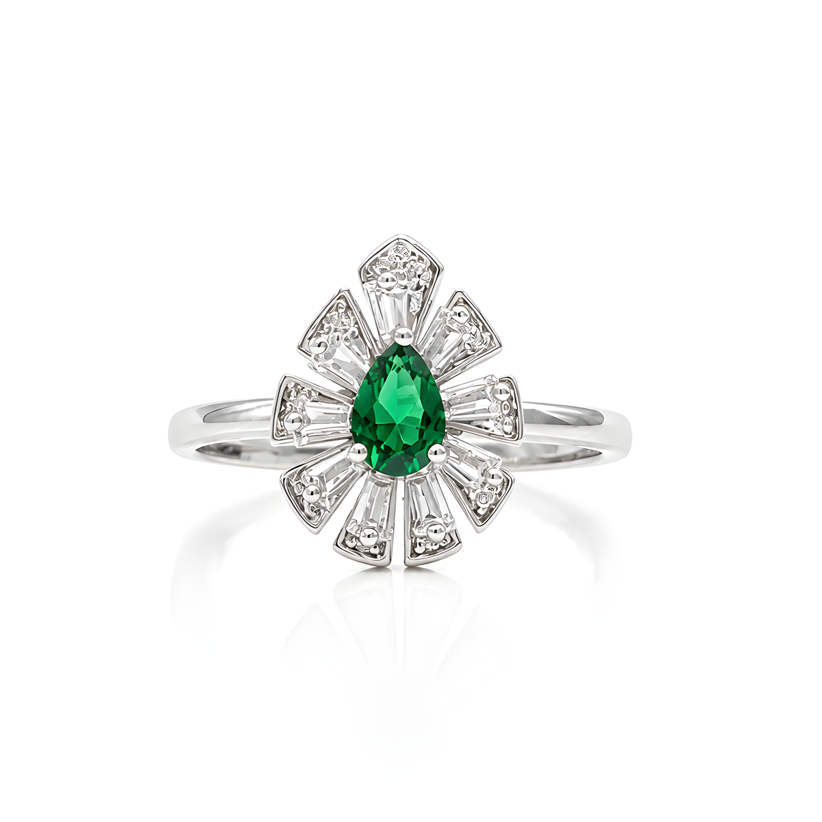 A silver ring featuring a pear-cut green emerald center stone surrounded by a fan-like cluster of small round and baguette-cut clear cubic zirconia.